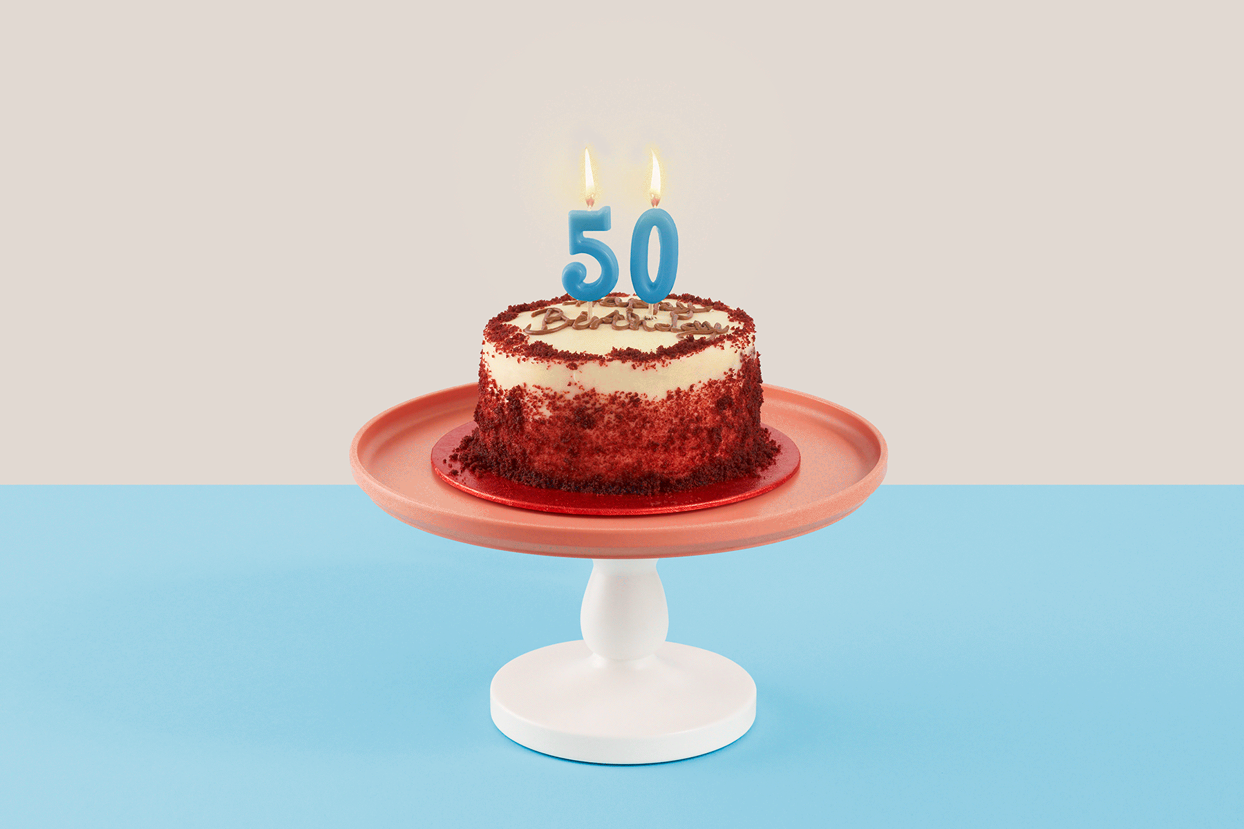 An image of a birthday cake with two candles in the shape of a 50