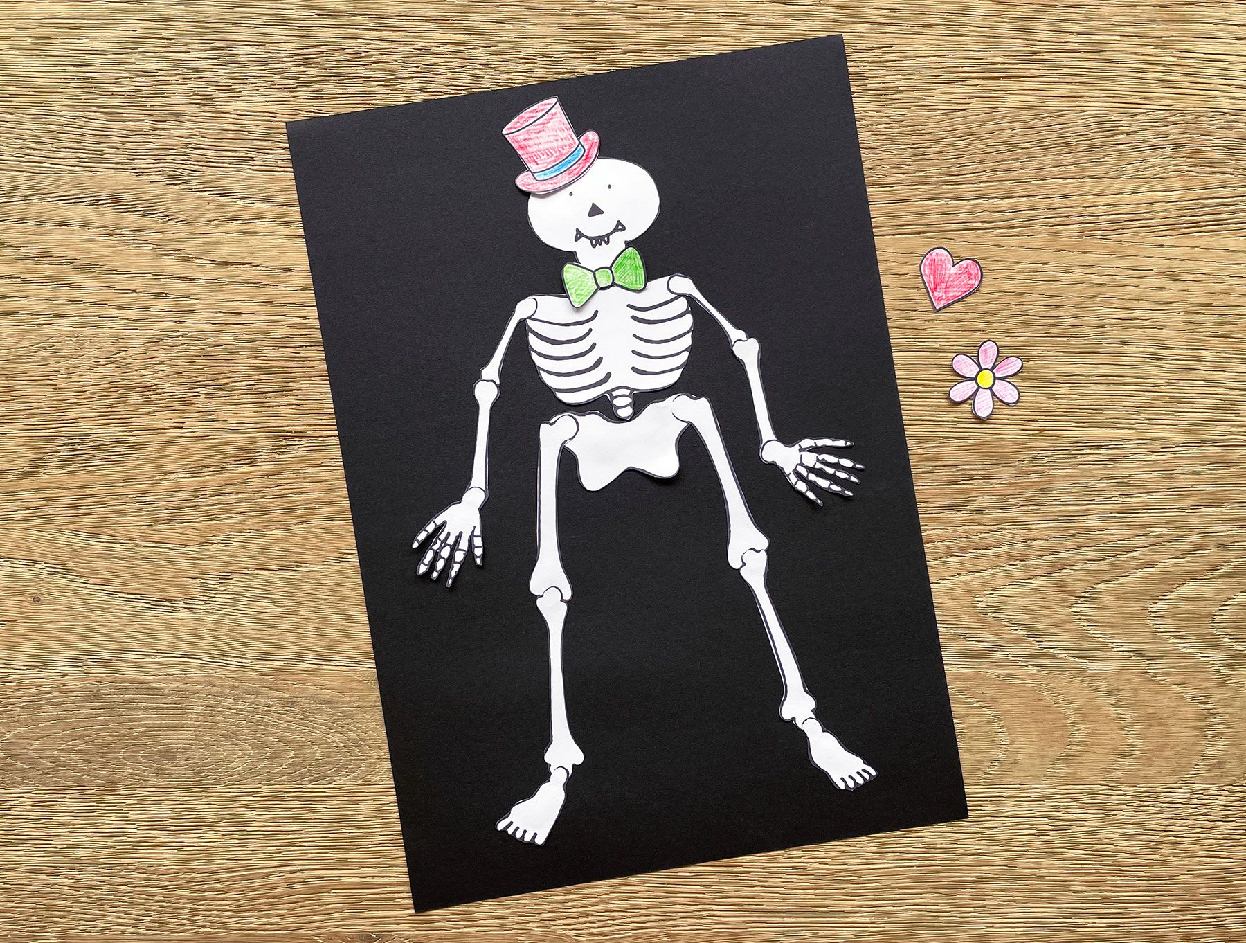 A photo of the completed Mr Funnybones stencil stuck onto a piece of black paper with the prop stencils next to it